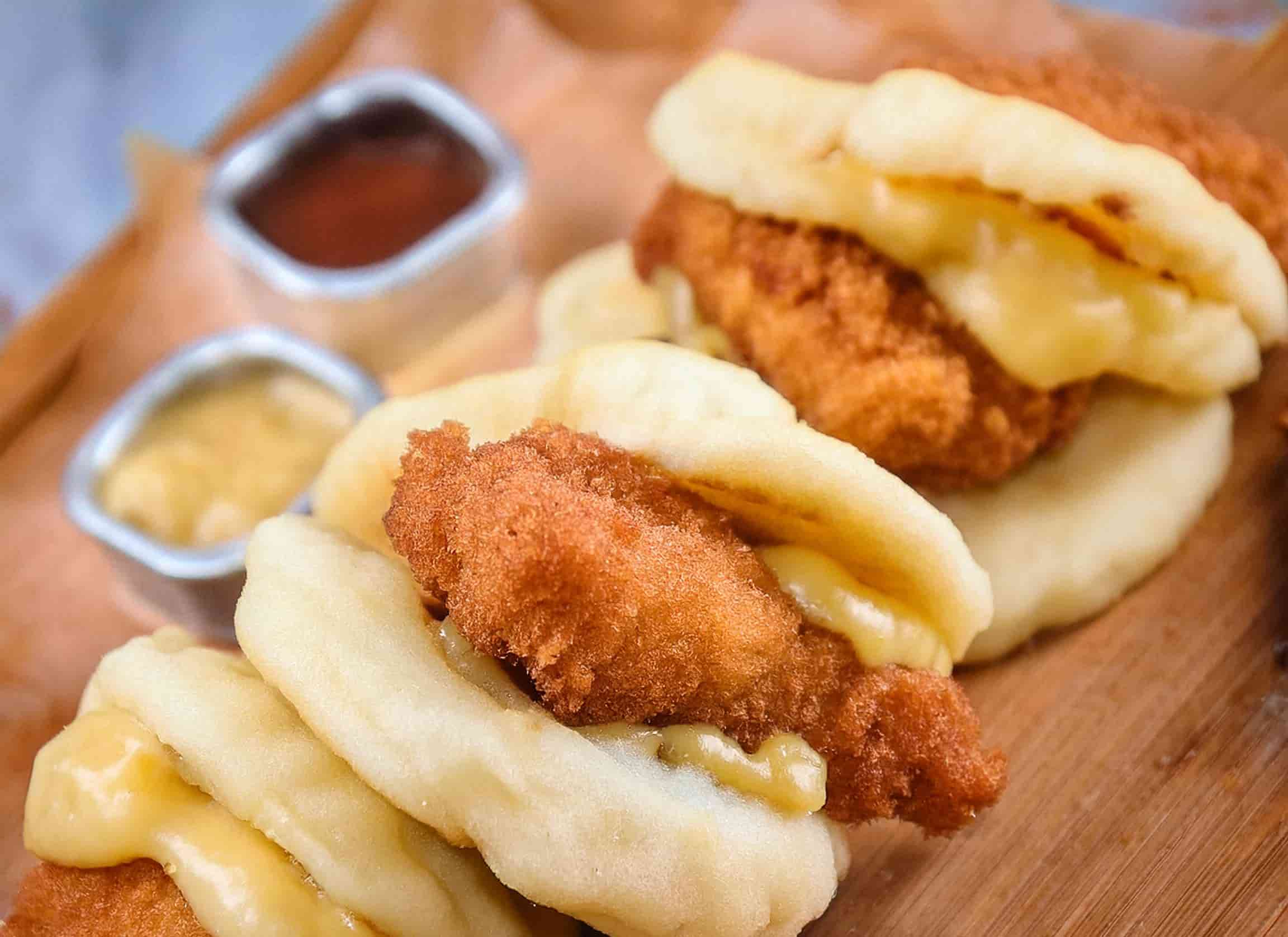Freshly baked Chicken Minis with golden rolls brushed with honey butter, served on a white platter.