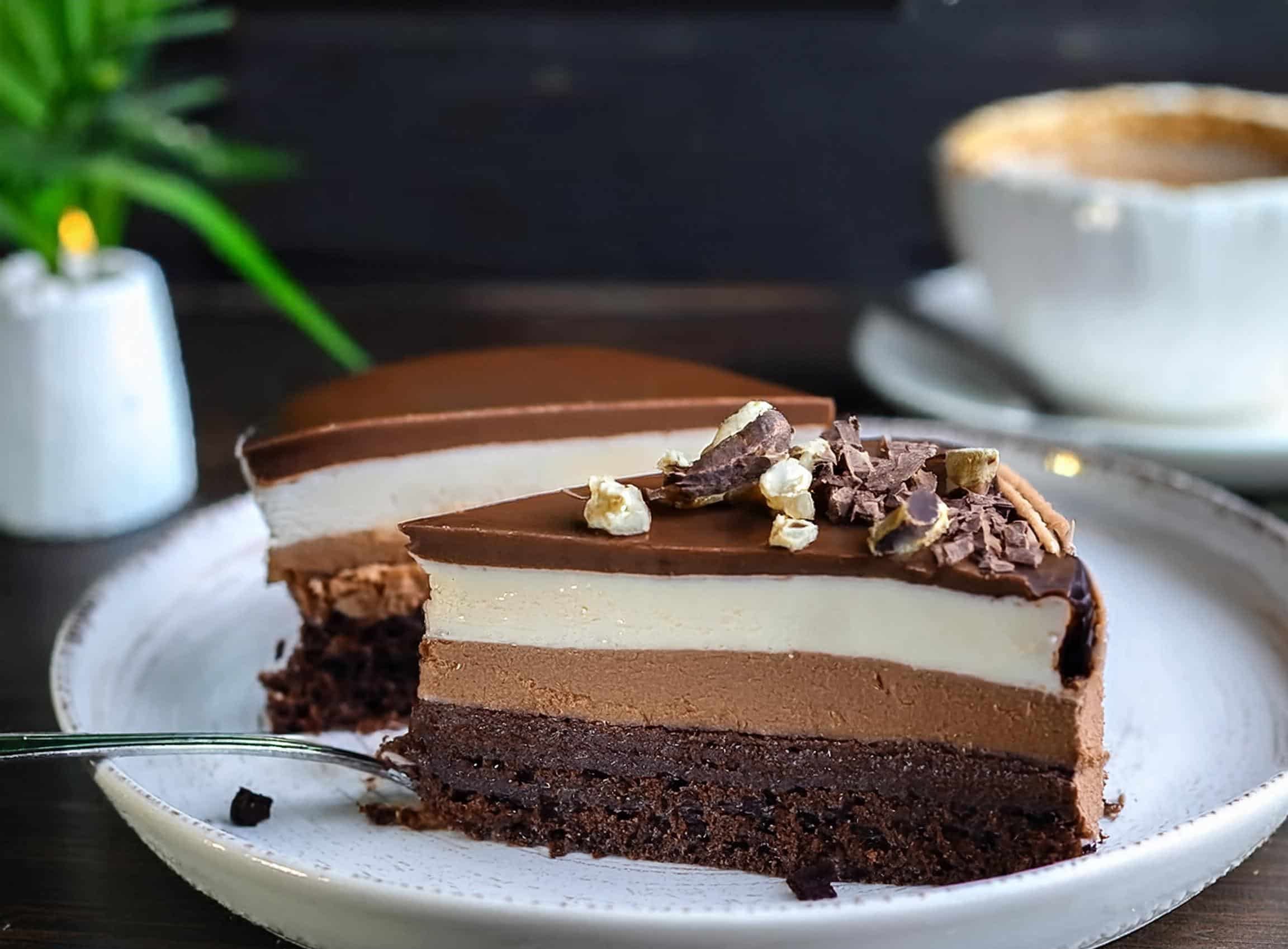 A single slice of Swiss Chocolate Chalet Cake showcasing its rich chocolate layers, creamy ganache, and delicate chalet-inspired decorations.