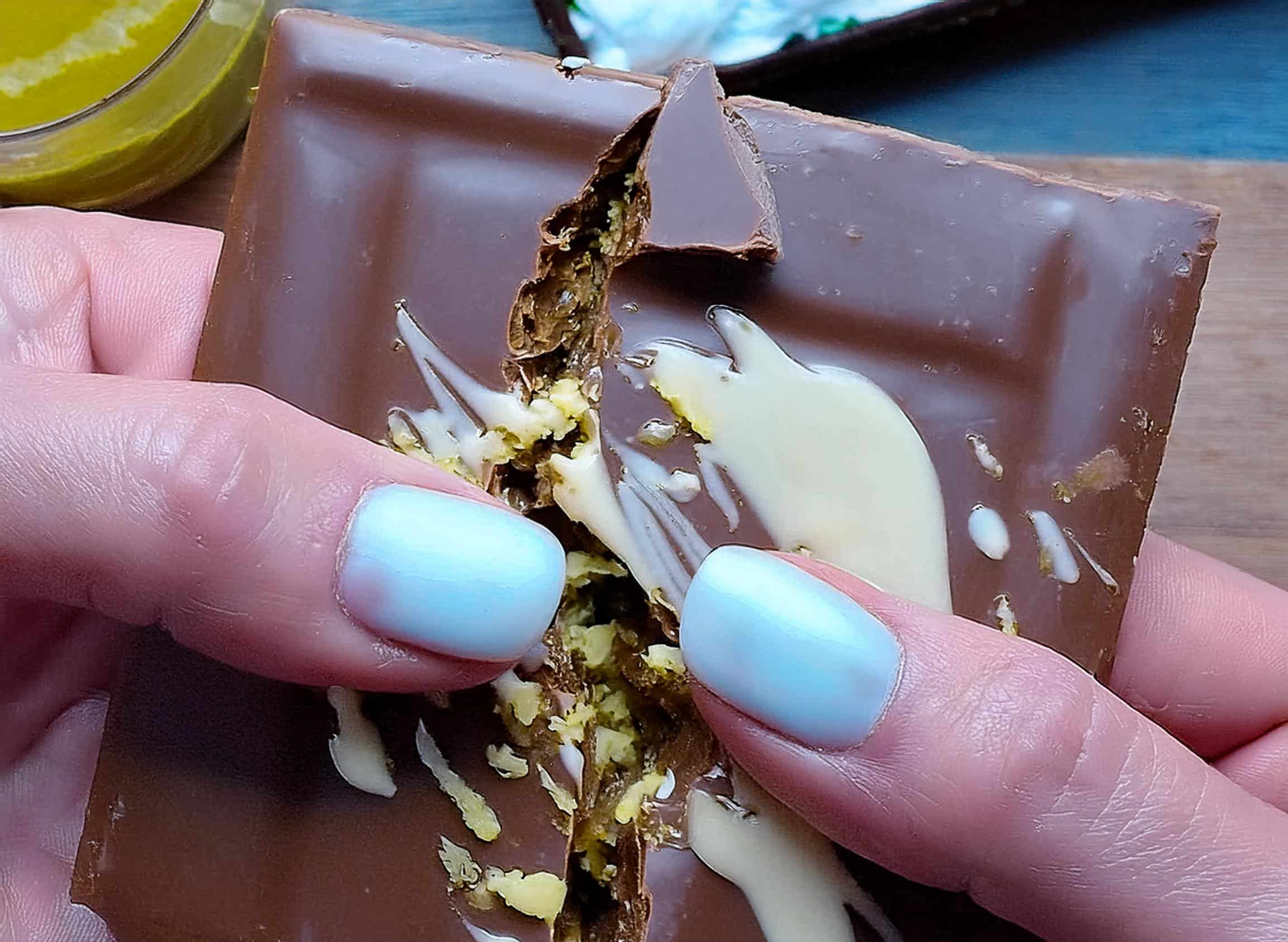 Dubai chocolate bars with a glossy dark chocolate shell, pistachio filling, and elegant white chocolate drizzle, served on a decorative platter